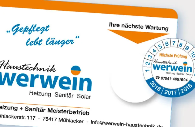 Grundplakette eines Heizungsbetriebs mit Feld für die nächste Wartung, daneben ein Prüfaufkleber mit Monats- und Jahresring