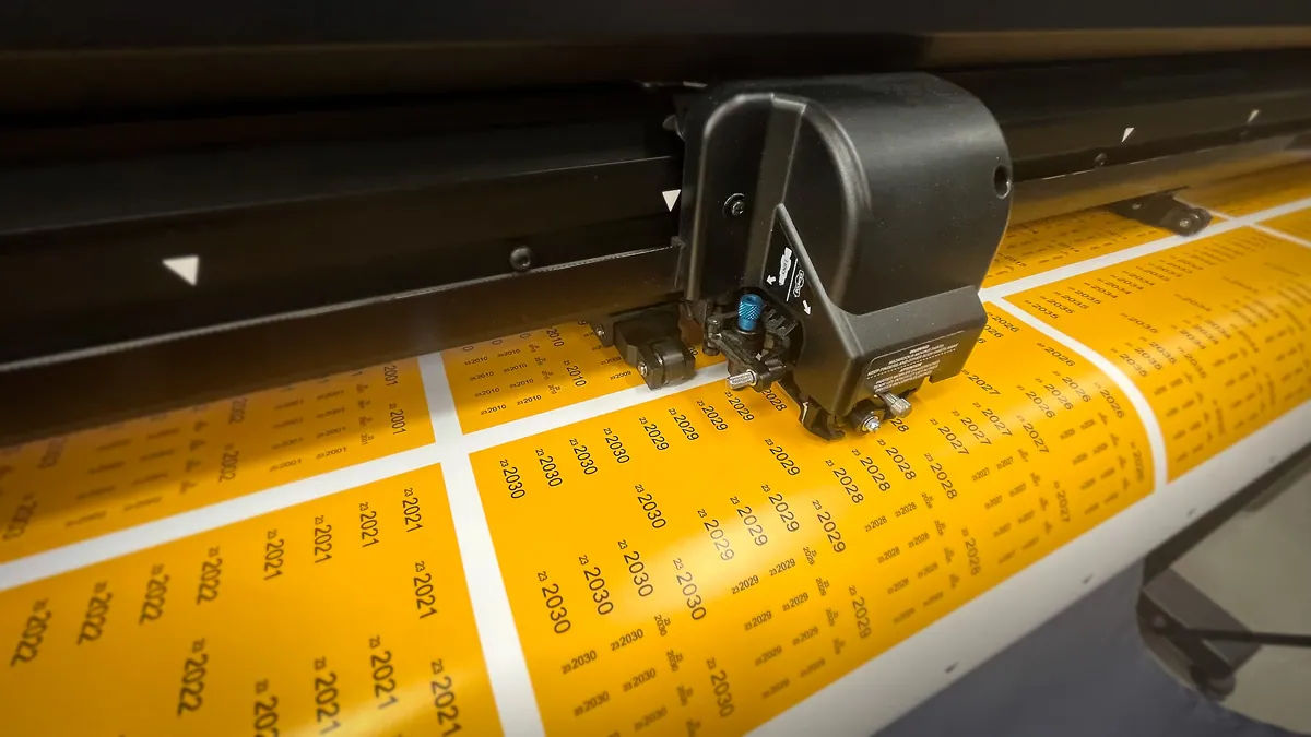 Prüfplaketten werden auf dem Schneideplotter konturgeschnitten